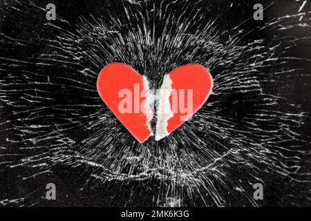 Broken love concept with torn paper heart on crashed glass smartphone touchscreen Stock Photo