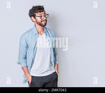 Young man wondering with hand in pocket over isolated background, handsome guy thinking looking to side Stock Photo