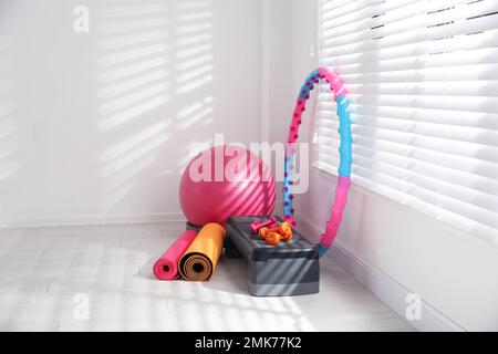 Different sports equipment near window in gym Stock Photo
