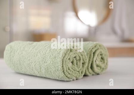 https://l450v.alamy.com/450v/2mk78gn/clean-rolled-towels-on-white-wooden-table-in-bathroom-2mk78gn.jpg