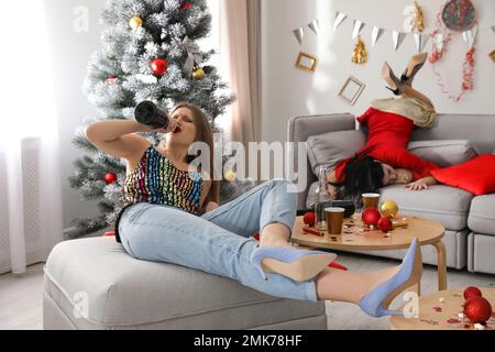 Drunk women in messy room after New Year party Stock Photo