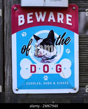 Humorous sign warning of the dog, BEWARE OF THE DOG, CUDDLES, HUGS & KISSES, Stuttgart. Baden-Wuerttemberg, Germany Stock Photo