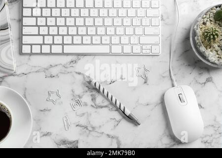 Flat lay composition with mouse and keyboard on white marble table Stock Photo