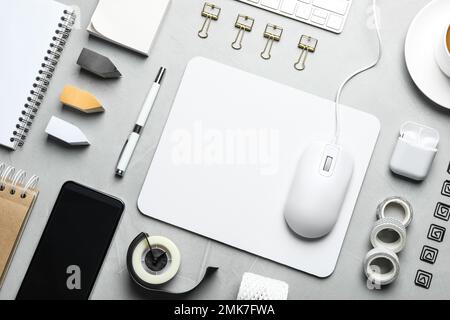 Flat lay composition with wired computer mouse and stationery on light grey table Stock Photo