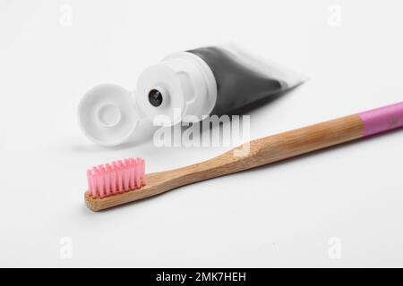 Bamboo toothbrush and charcoal paste isolated on white Stock Photo