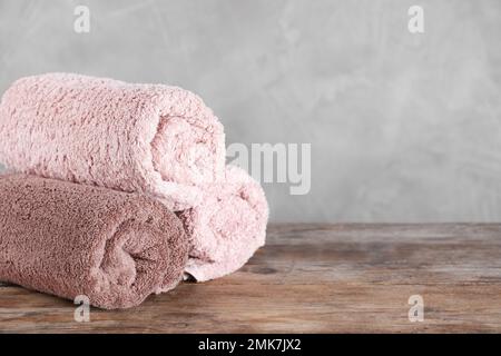 https://l450v.alamy.com/450v/2mk7jx2/rolled-bath-towels-on-wooden-table-space-for-text-2mk7jx2.jpg