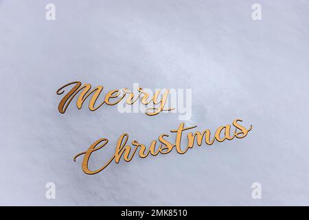 inscription in gold letters on the snow, Merry Christmas. winter holidays. Stock Photo