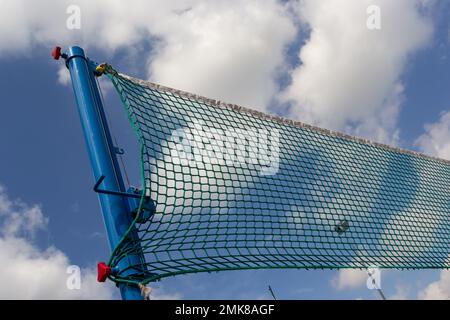 Tennis or volleyball net against blue sky. Beautiful cirrus clouds. Beautiful cirrus clouds over the sports field. Stock Photo