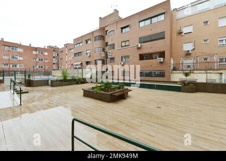 Interior common areas of an interior block patio with a swimming pool and stoneware floors in an urban residential development on a rainy day Stock Photo