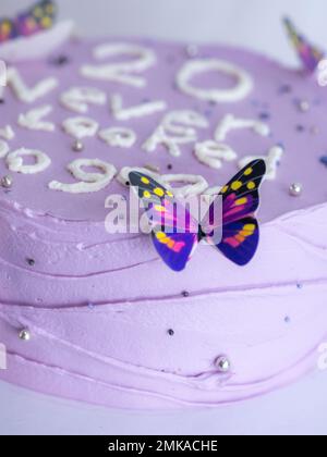 20 years old frosted cake decorated with a cream handmade phrase, butterflies, pearls , sprinkles by baker designer Stock Photo