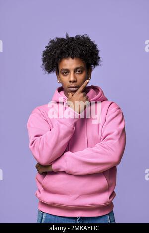 Cool African teen guy wearing pink hoodie isolated on light purple. Vertical Stock Photo