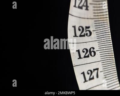 Close-up white measuring tape on black background. Stock Photo