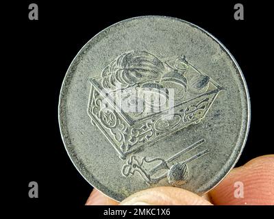 Closeup finger holding old 20 cent Malaysia coin on a black background. Stock Photo
