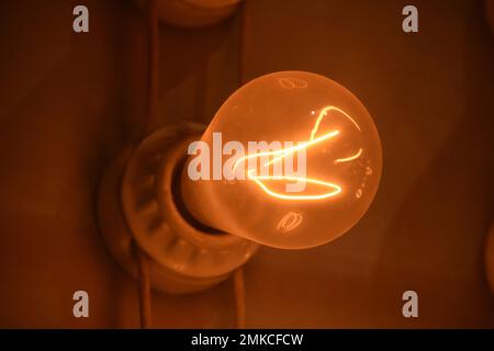 Electrical current flowing through a filament in an old style lightbulb. Stock Photo