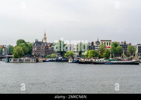 AMSTERDAM, THE NETHERLANDS - AUGUST 24, 2013: View of Amsterdam with the river and boats, in the area of the central train station Stock Photo