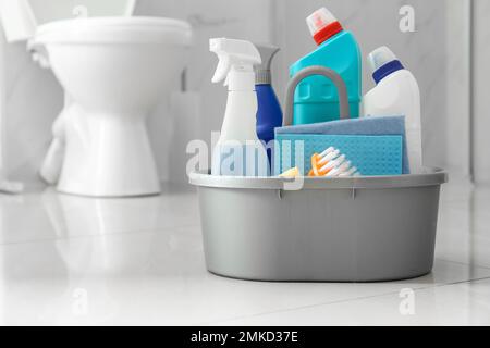 Cleaning supplies and toilet bowl in bathroom. Space for text