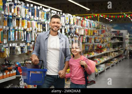 Little girl with father choosing school stationery in supermarket Stock Photo