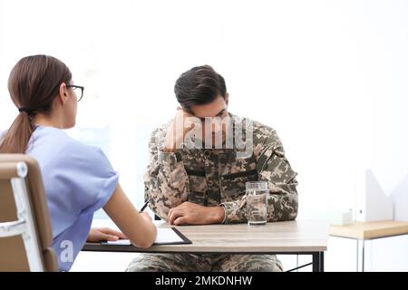 Psychotherapist working with male military officer in office Stock Photo