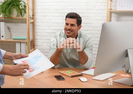 Colleagues making schedule using calendar in office Stock Photo