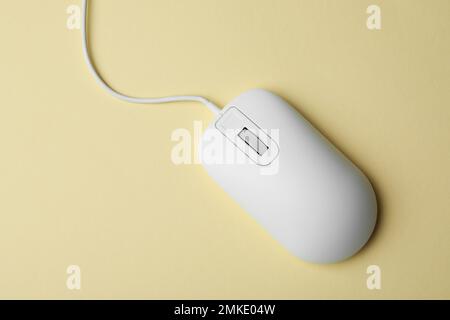 Wired computer mouse on yellow background, top view Stock Photo