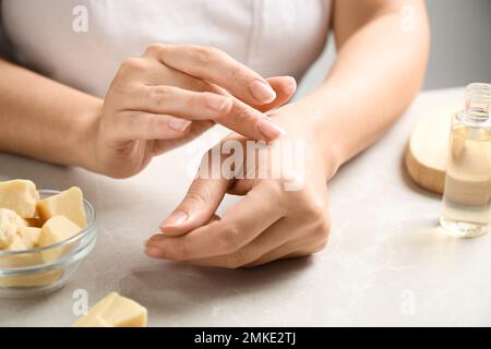 Woman applying organic cocoa butter at table, top view Stock Photo - Alamy