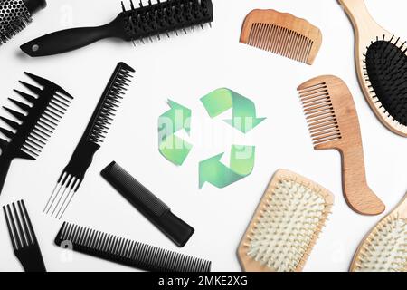 Recycling symbol and different hairbrushes on white background, top view Stock Photo