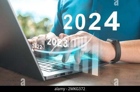 2024 new year. Business person using laptop with hologram growth chart. Business success and investment growth in 2024 years. Business finance technol Stock Photo