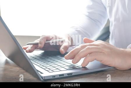 Close-up businessman typing on laptop at workplace. Close up businessman hands working computer laptop searching or typing text message for new projec Stock Photo