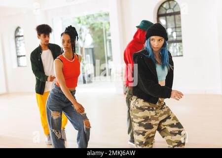 Image of group of group of diverse female and male hip hop dancers practicing in dance studio. Dance, rhythm, movement and training concept. Stock Photo