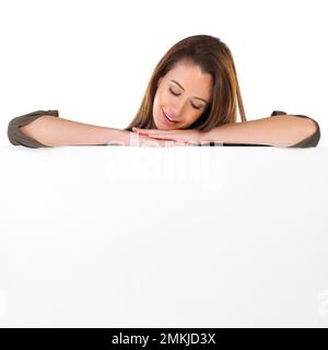 Looks like some great copyspace down here. Studio shot of a young woman leaning on a blank field of white copyspace. Stock Photo