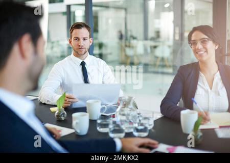 Gathered around the meeting table. a group of colleagues meeting in the boardroom. Stock Photo