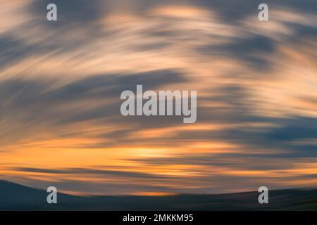 Sunset mountain round motion blur background. orange lines shadow cloudscape sky Stock Photo