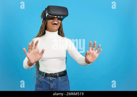African woman gesturing with hands while using a virtual goggles Stock Photo