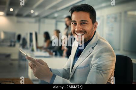 Our office uses only the best and latest technology. Portrait of a young businessman using a digital tablet in an office. Stock Photo