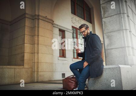 Connected to urban life. a stylish man using his phone in the city. Stock Photo