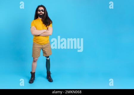 Serious man with arms crossed standing with a prosthetic leg Stock Photo
