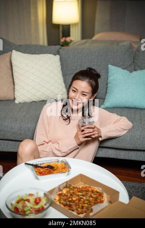 The young lady at home eating take-away Stock Photo