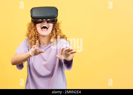 Surprised woman smiling while using virtual reality goggles Stock Photo