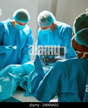 Group of surgeons looking at patient on operation table during their ...