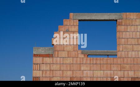 Single-family home made of hollow blocks or bricks. New unfinished stand-alone house building under construction. Stock Photo