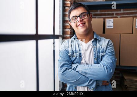 Down syndrome man ecommerce business worker standing with arms crossed gesture at office Stock Photo