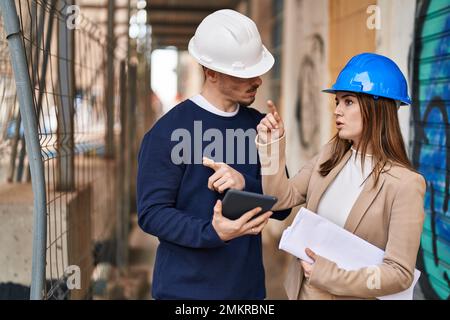 Mand and woman architects using touchpad speaking at street Stock Photo