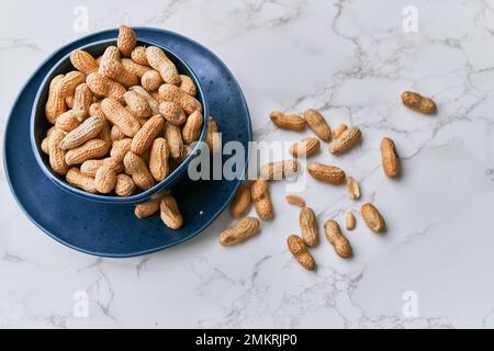 Image of bunch of peanuts in a bowl on a marble table Stock Photo