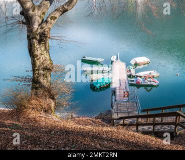 Lake Ledro (Ledro Valley) and the surrounding mountains on a clear spring day. A boat landing stage and some boats. Trentino Alto Adige - Italy Stock Photo