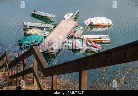 Lake Ledro (Ledro Valley) and the surrounding mountains on a clear spring day. A boat landing stage and some boats.Trento,Trentino Alto Adige,Italy Stock Photo