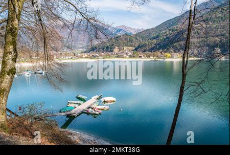 Lake Ledro (Ledro Valley) and the surrounding mountains on a clear spring day. A boat landing stage and some boats.Trento,Trentino Alto Adige,Italy Stock Photo