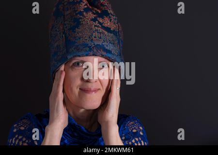 Nice low key portrait of mature Ukrainian  woman in in blue oriental clothes Stock Photo