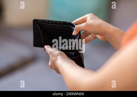Closeup Shot Of Unrecognizable Female Holding Empty Wallet At Home Stock Photo