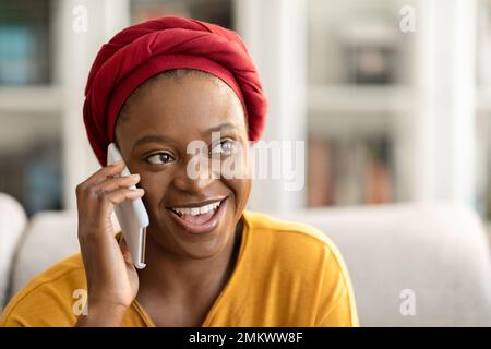 Closeup of happy young black woman having phone conversation Stock Photo