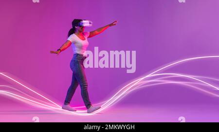 Amazed Black Woman In Vr Glasses Walking On Glowing Neon Light Lines Stock Photo